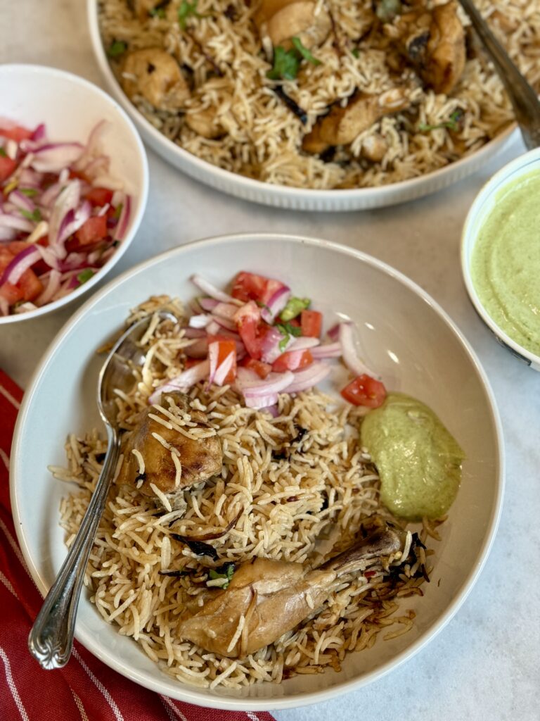 Pakistani chicken pulao served in white plate with kachumber salad and raita 